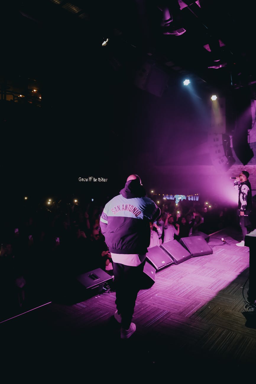 man in hoodie jacket standing on stage