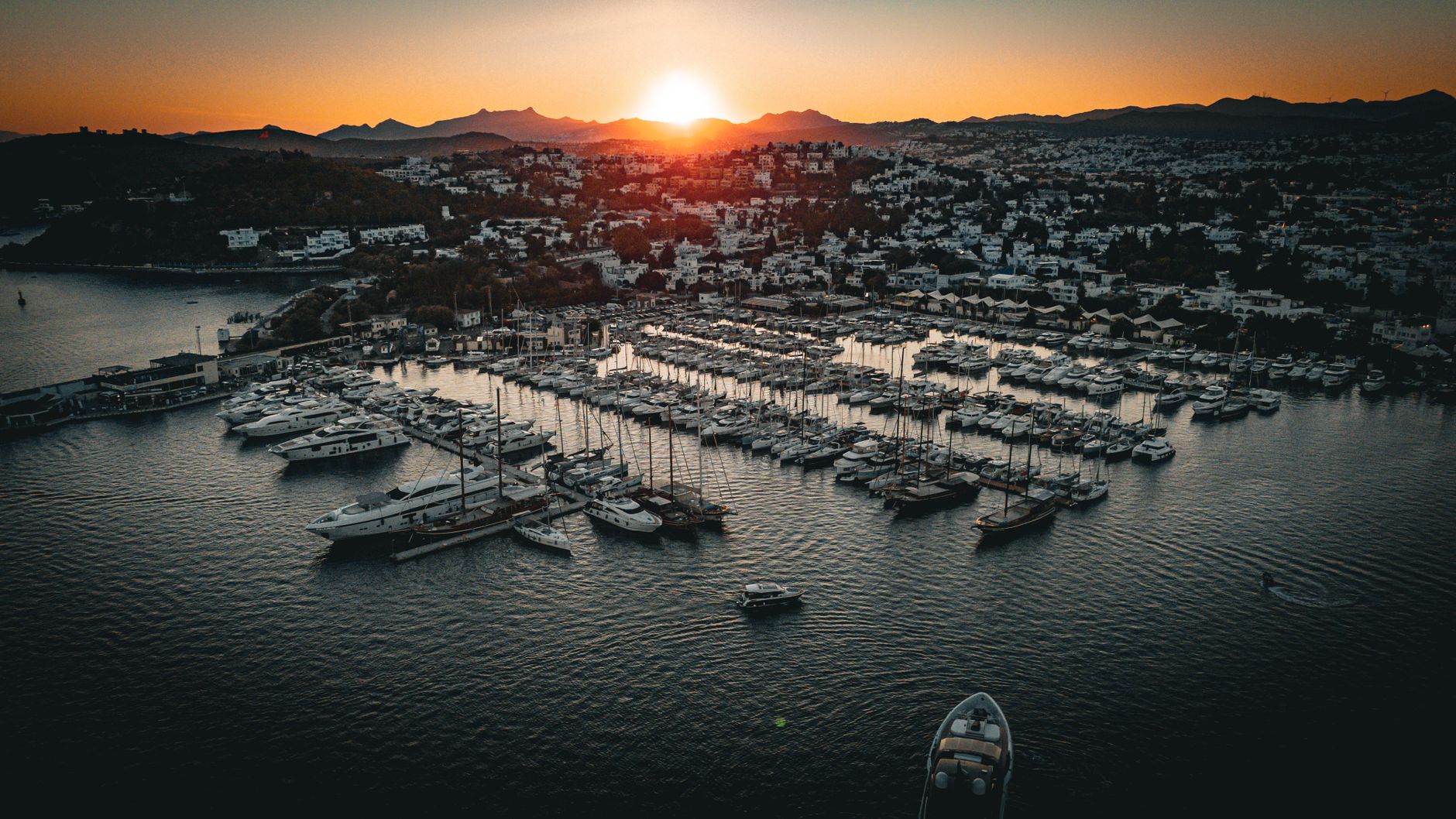 sunset over bodrum marina with boats and yachts